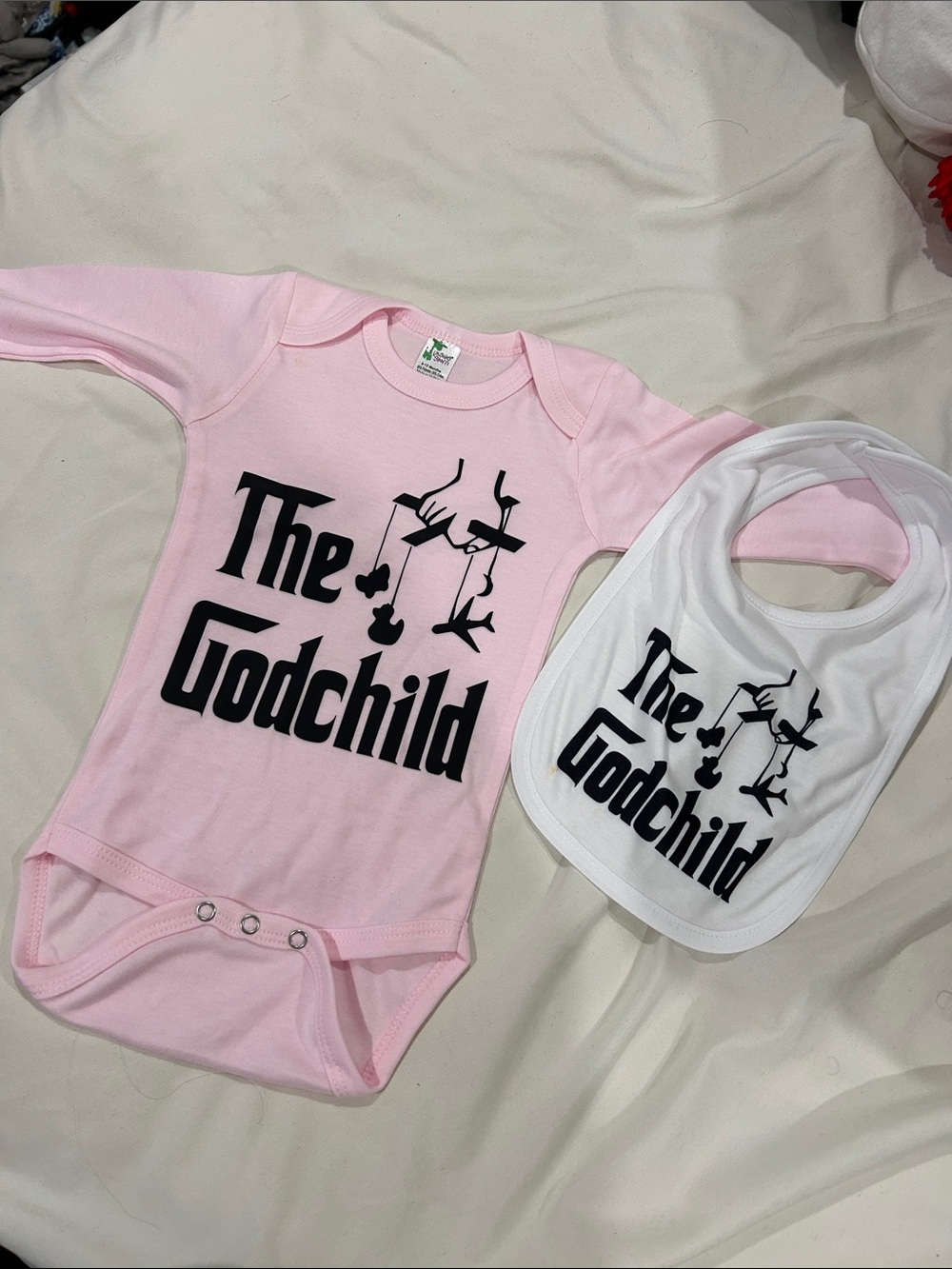 The Godchild Pink Baby Bodysuit & White Bib Set